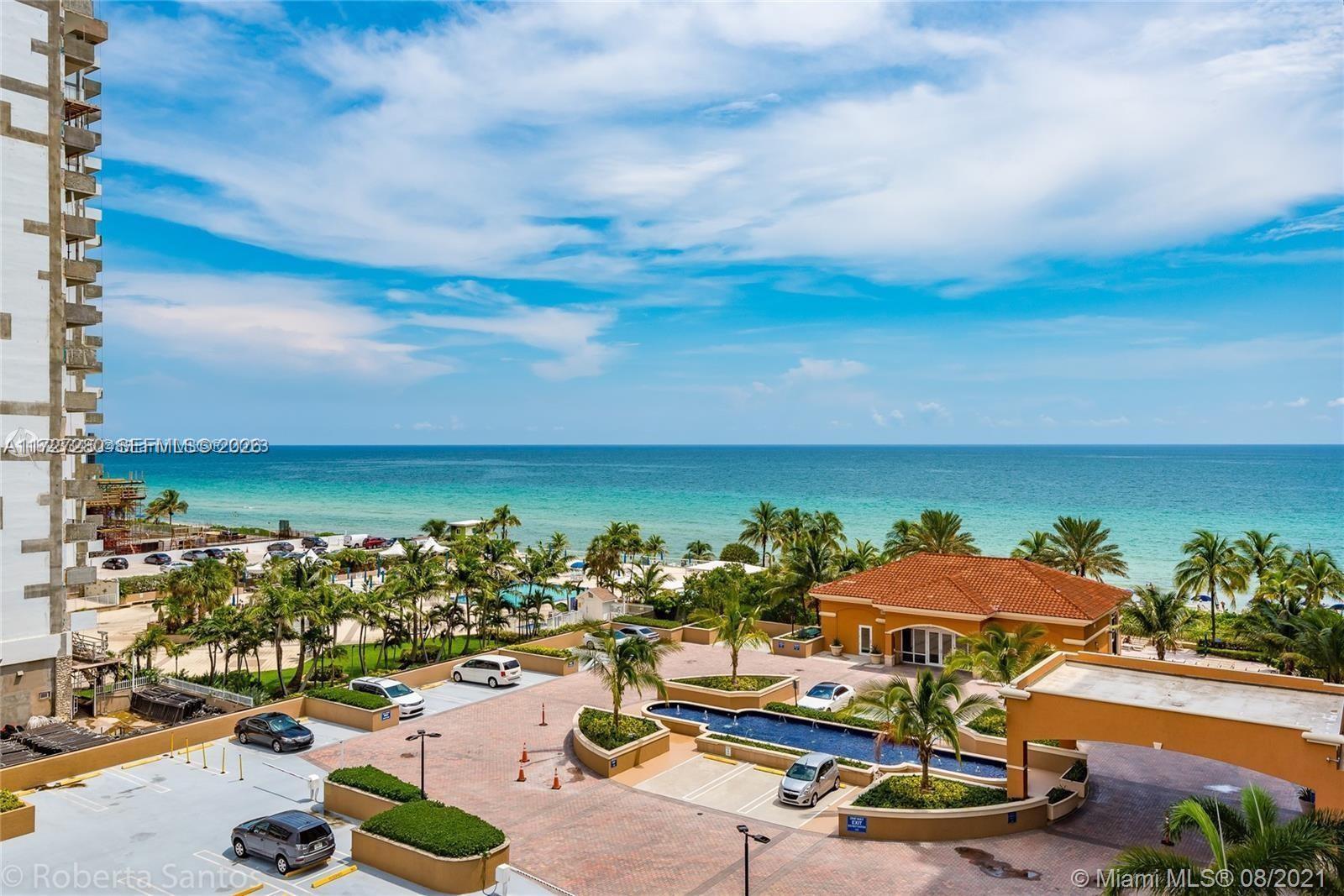 An elevated view shows a parking lot, a building entrance, and the ocean beyond — 2080 S Ocean Dr # 502, Hallandale Beach FL 33009, HALLANDALE BEACH, FL