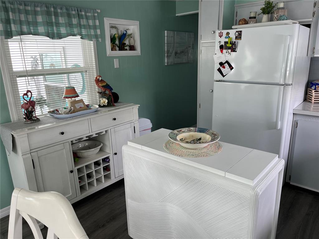 A kitchen features a white cabinet, a white refrigerator, and a white kitchen island — 1413 24TH AVENUE W, BRADENTON, FL