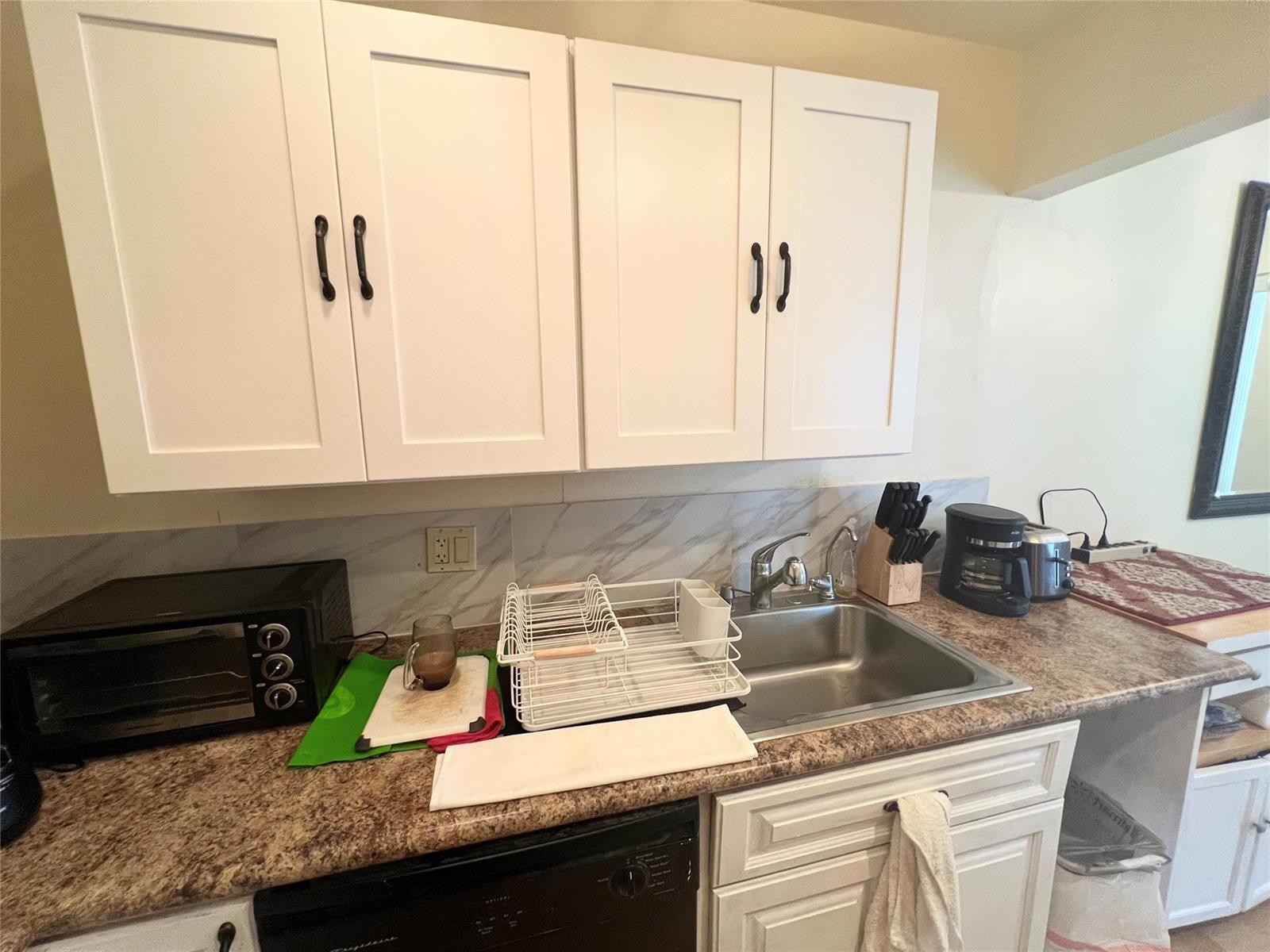 A kitchen features white cabinets, a stainless steel sink, and a brown laminate countertop — 191 Markham I # 191, Deerfield Beach FL 33442, DEERFIELD BEACH, FL
