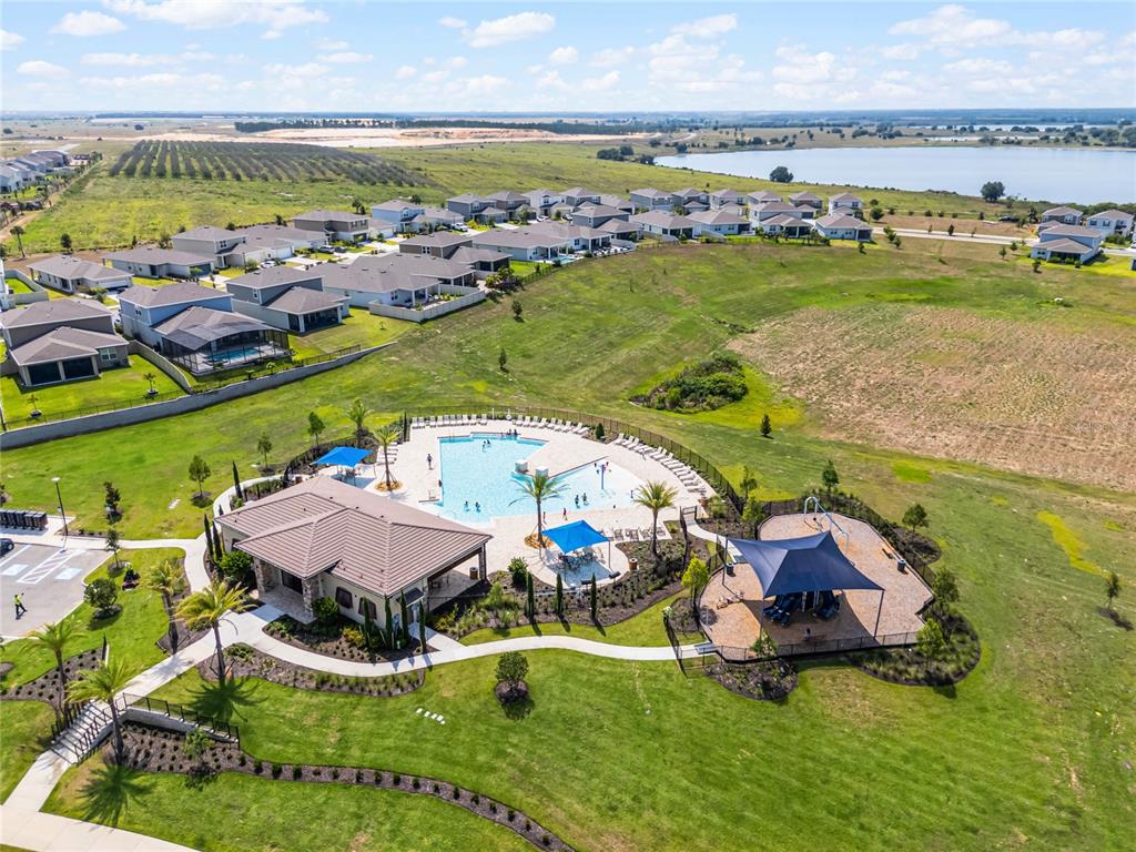 An aerial view shows a community clubhouse with a swimming pool and playground — 7798 SYRACUSE DRIVE, CLERMONT, FL