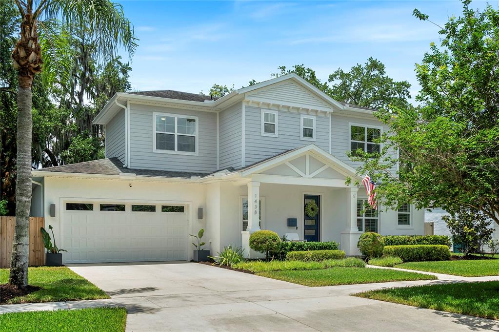 A two-story house with light gray siding, a white garage, and a covered front porch — 1438 W HARVARD STREET, ORLANDO, FL