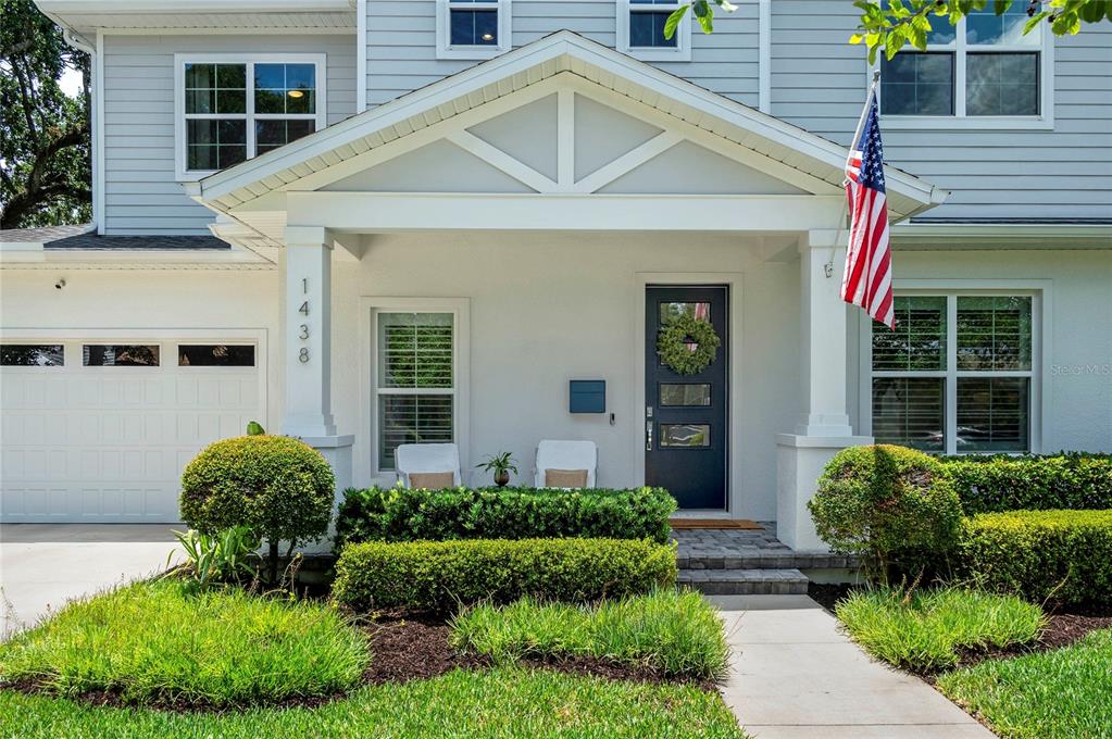 The exterior of a two-story house features a covered front porch and a paved walkway — 1438 W HARVARD STREET, ORLANDO, FL