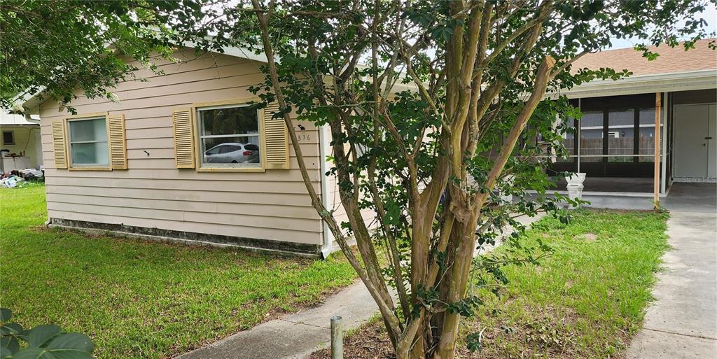A beige single-story house features a screened-in porch and a tree in the front yard — 3576 SW 147TH LANE ROAD, OCALA, FL