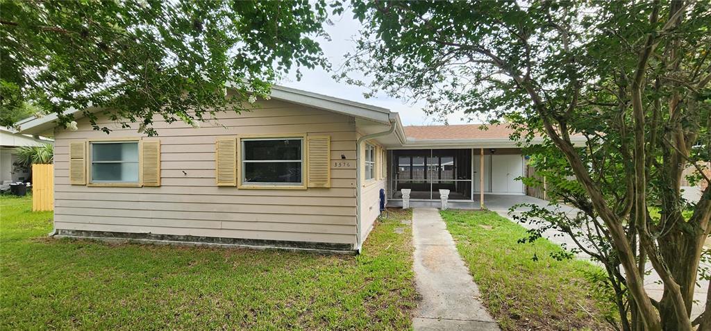 A single-story house with light-colored siding, a screened-in porch, and a concrete driveway — 3576 SW 147TH LANE ROAD, OCALA, FL