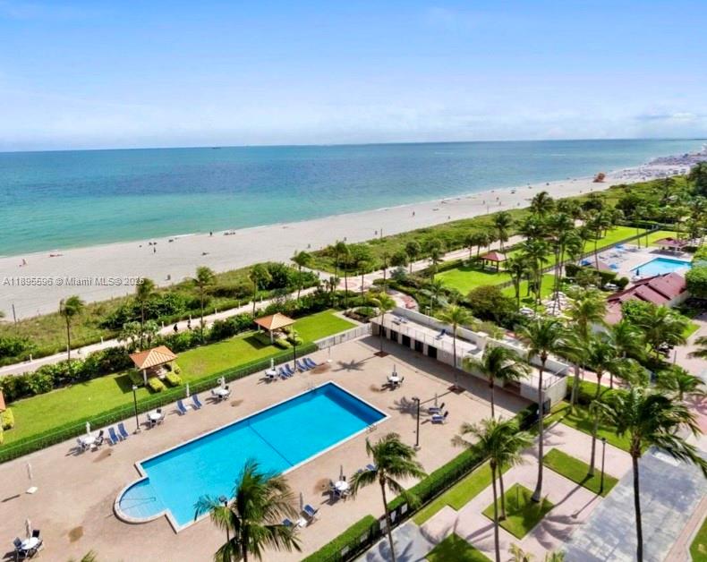 An aerial view shows a rectangular swimming pool, palm trees, and a sandy beach — 2625 Collins Ave # 1507, Miami Beach FL 33140, MIAMI BEACH, FL
