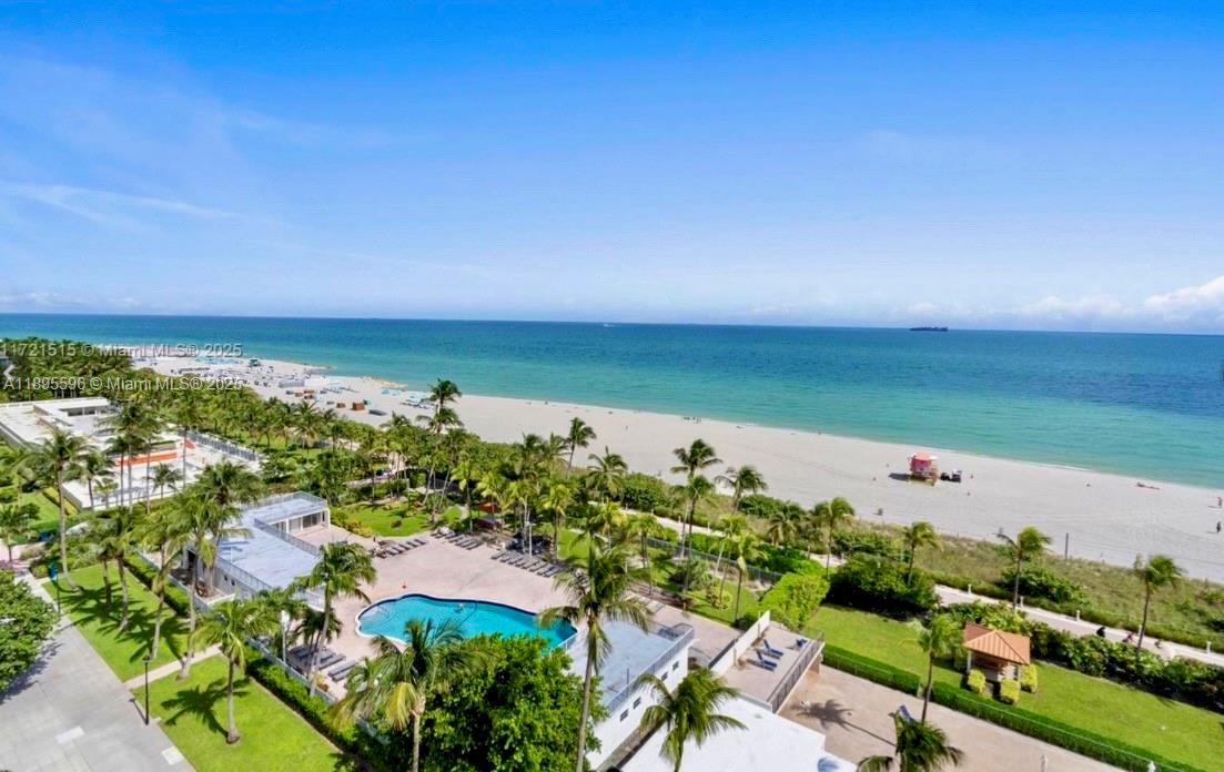An aerial view shows a swimming pool, palm trees, and a sandy beach by the ocean — 2625 Collins Ave # 1507, Miami Beach FL 33140, MIAMI BEACH, FL