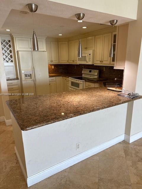 A kitchen features a granite breakfast bar, beige cabinets, and three hanging pendant lights — 2625 Collins Ave # 1507, Miami Beach FL 33140, MIAMI BEACH, FL