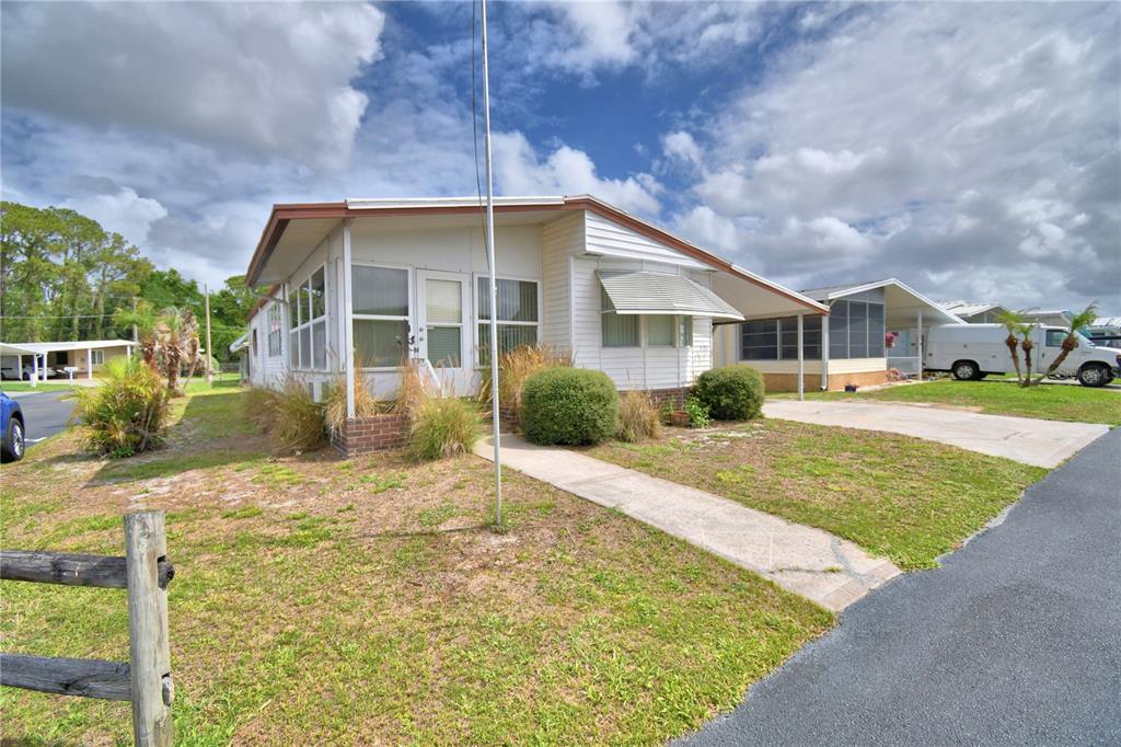 A white mobile home with a screened-in porch and a concrete driveway under a cloudy sky — 4155 SPRUCEWOOD STREET, WINTER HAVEN, FL