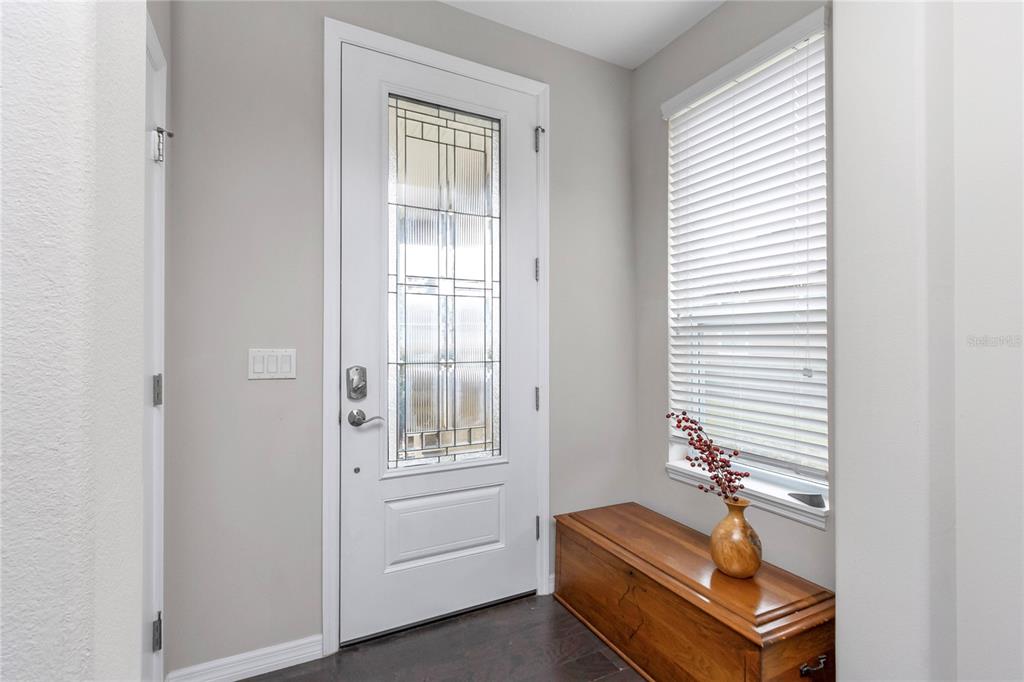 An entryway features a white front door with decorative glass, a wooden bench, and blinds — 5423 NW 35TH LANE ROAD, OCALA, FL