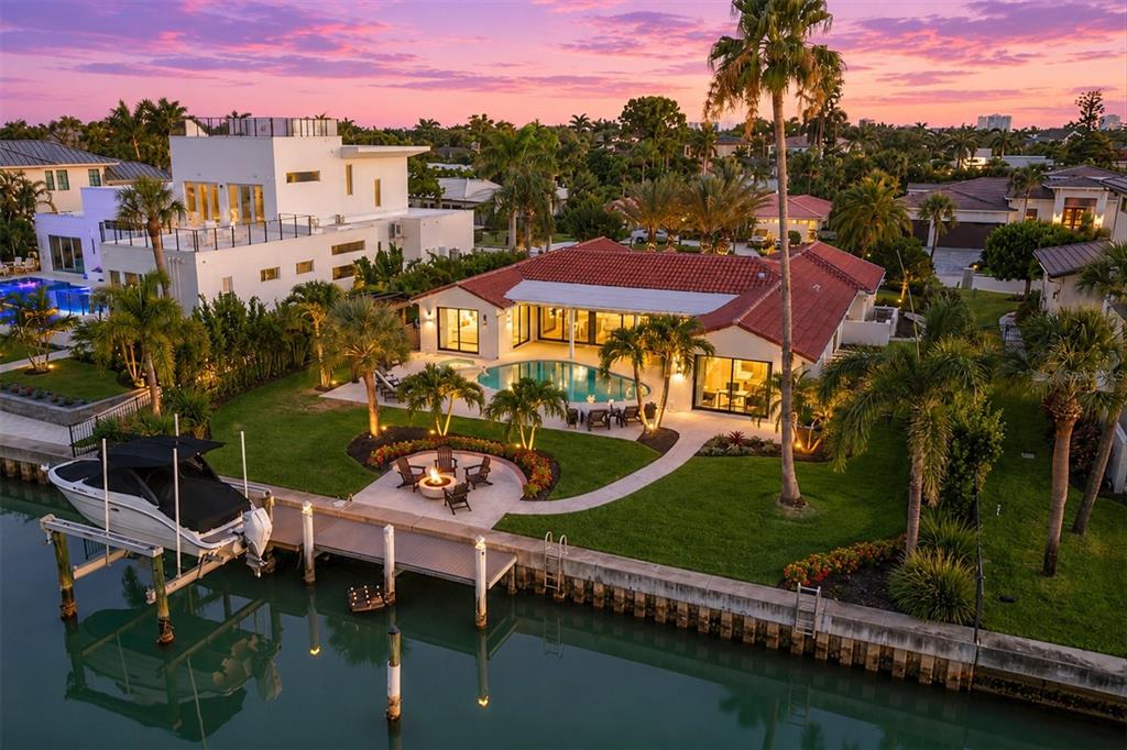 An aerial view of a waterfront home with a pool, fire pit, and boat lift — 465 E ROYAL FLAMINGO DRIVE, SARASOTA, FL