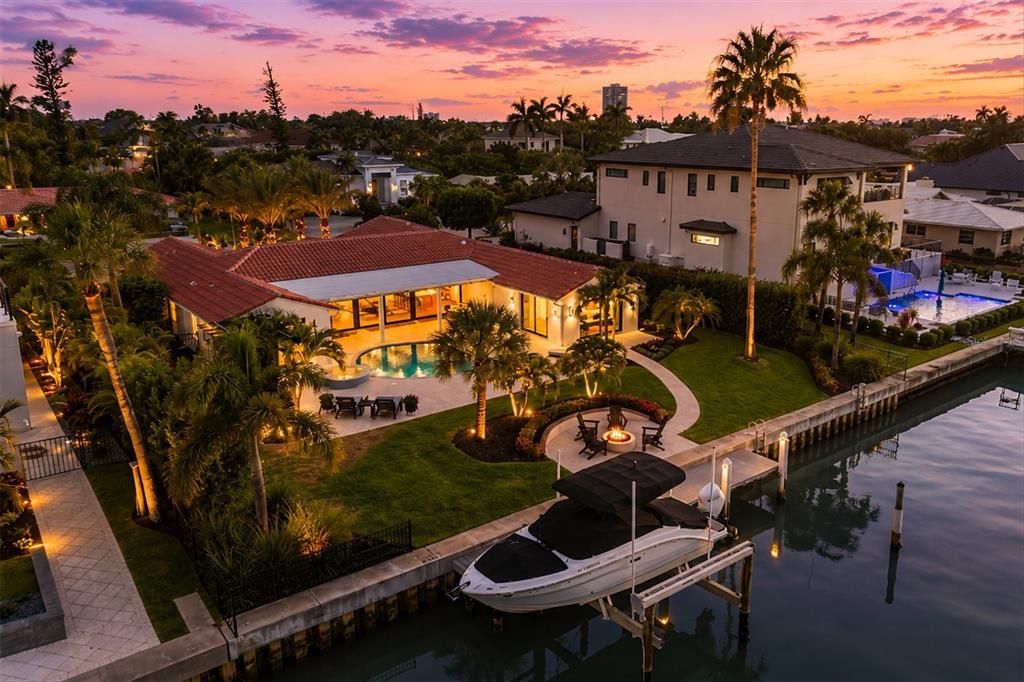 An aerial view of a waterfront house with a pool, boat lift, and fire pit — 465 E ROYAL FLAMINGO DRIVE, SARASOTA, FL