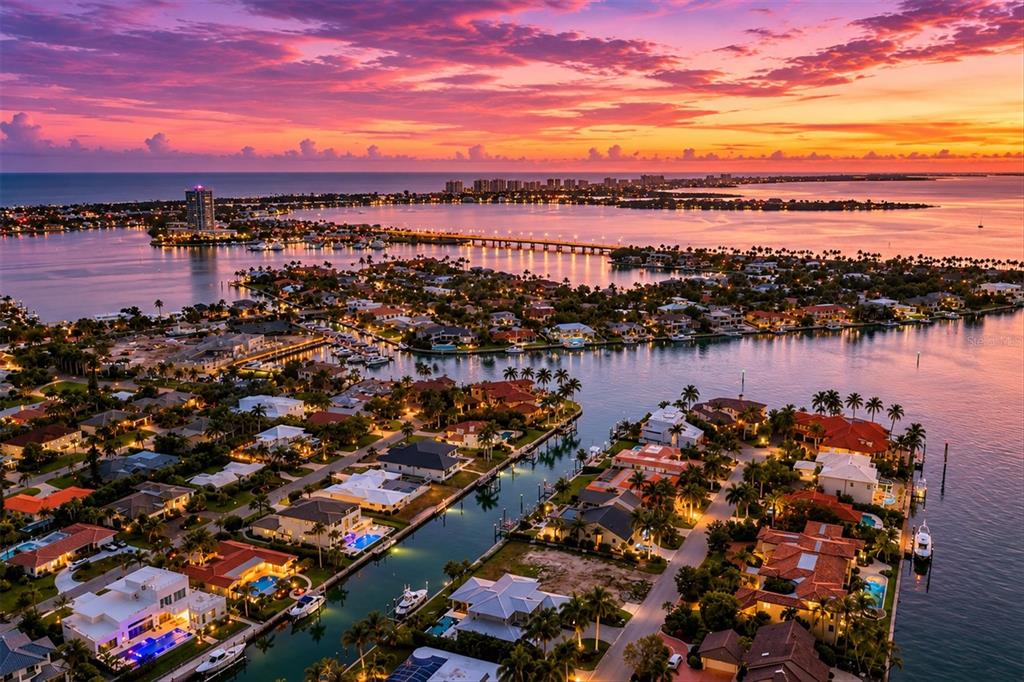 An aerial view of a waterfront residential neighborhood at sunset with a bridge in distance — 465 E ROYAL FLAMINGO DRIVE, SARASOTA, FL
