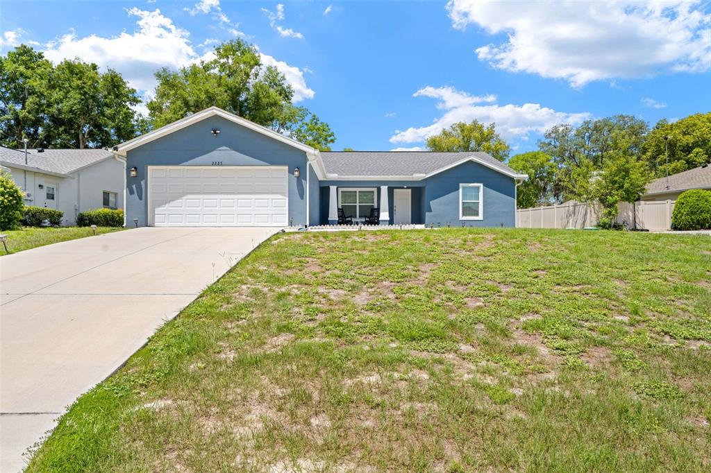 A blue single-story house with a two-car garage and a large front lawn — 2225 RING ROAD, SPRING HILL, FL