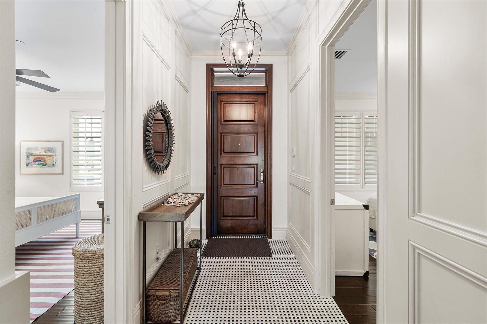 A hallway with white paneled walls, a patterned tile floor, and a dark wood door — 400 S Ocean Boulevard # 105, Delray Beach FL 33483, DELRAY BEACH, FL