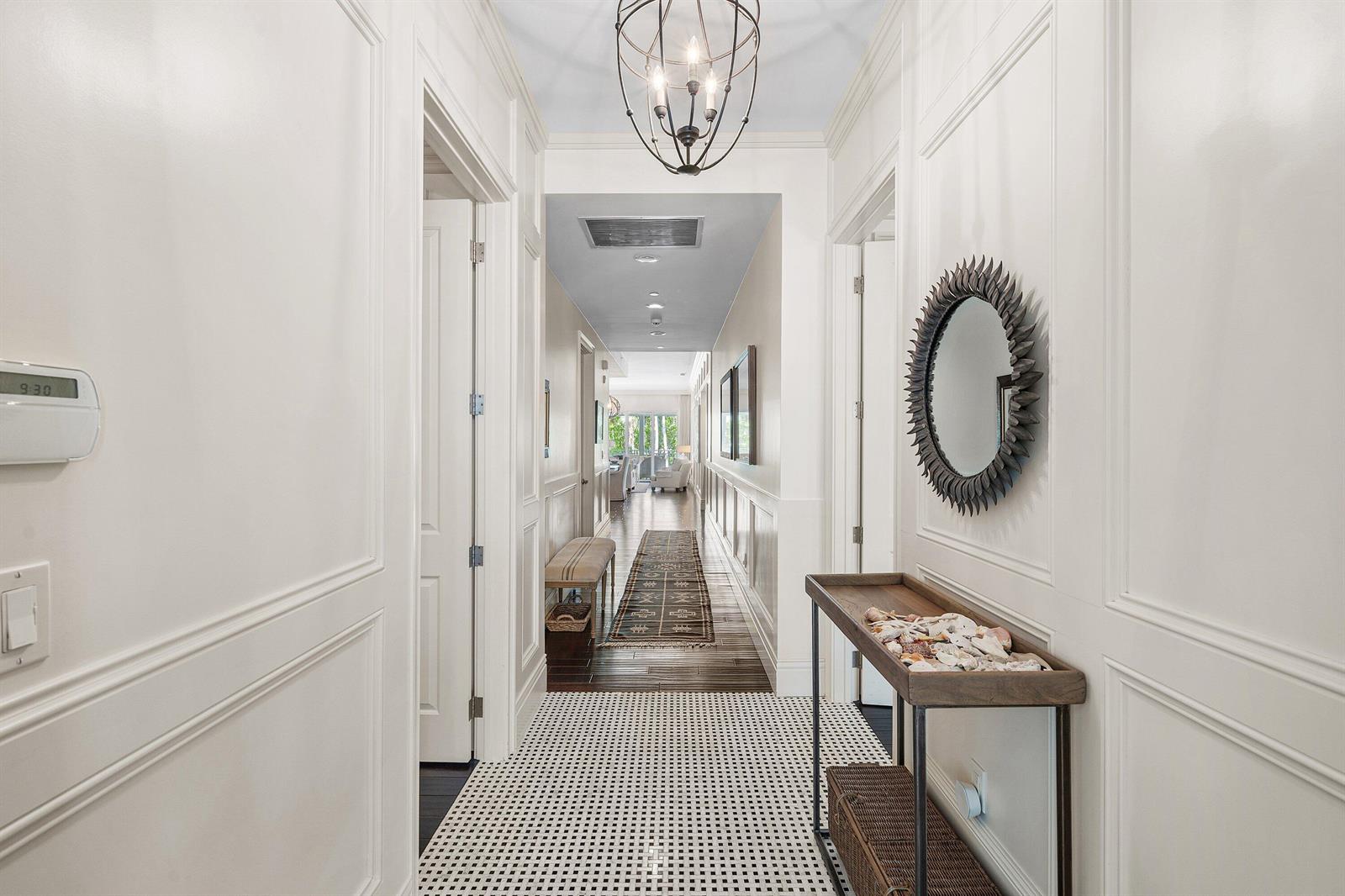 A bright hallway features white paneled walls, a black-and-white tiled floor, and a console table — 400 S Ocean Boulevard # 105, Delray Beach FL 33483, DELRAY BEACH, FL