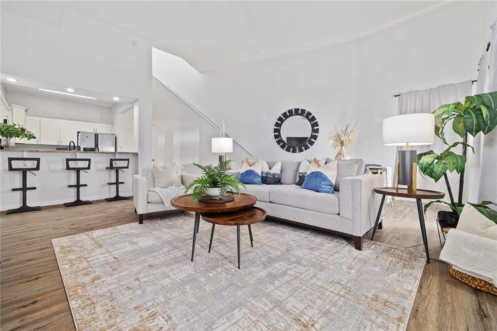 A living room features a light gray sofa, wooden coffee tables, and an open kitchen — 9415 CITRUS GLEN PLACE, TAMPA, FL