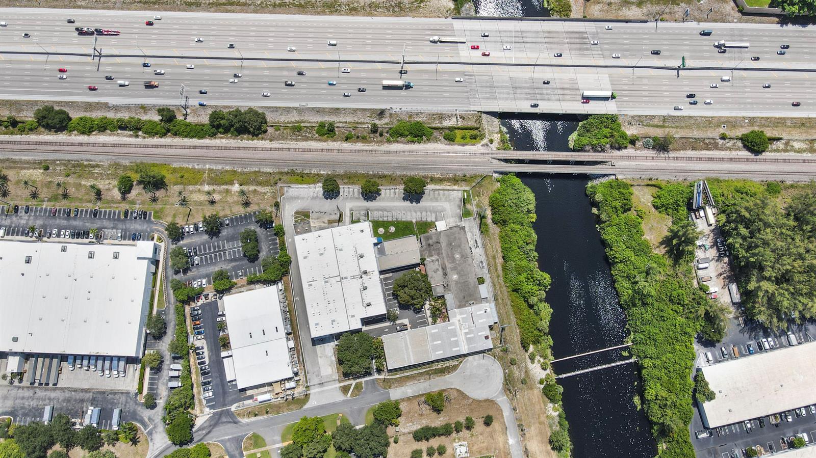 Aerial view of industrial buildings, a canal, railroad tracks, and a multi-lane highway — 1500 High Ridge Road, Boynton Beach FL 33426, BOYNTON BEACH, FL