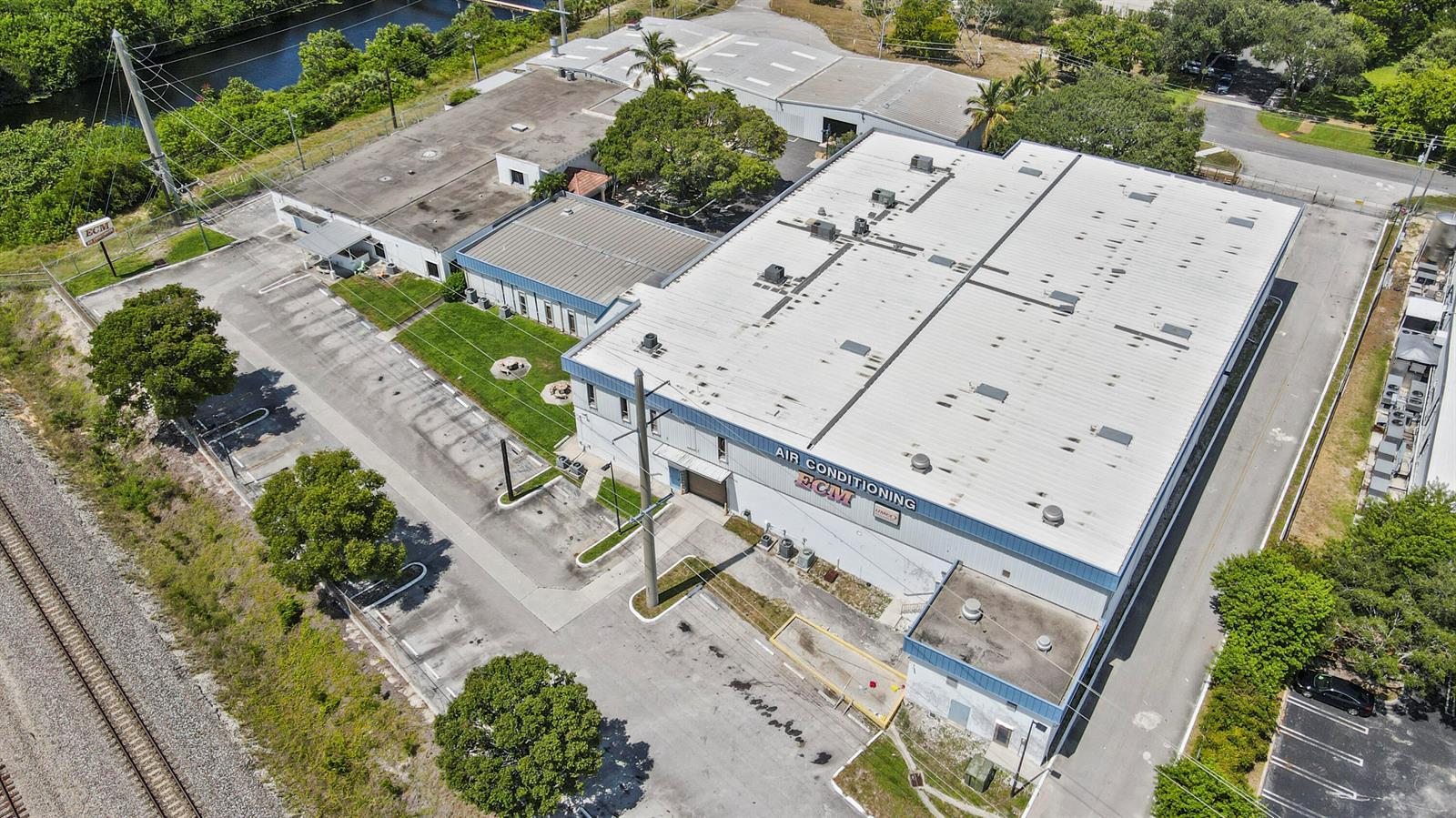 An aerial view shows a commercial building with a large metal roof and parking lot — 1500 High Ridge Road, Boynton Beach FL 33426, BOYNTON BEACH, FL