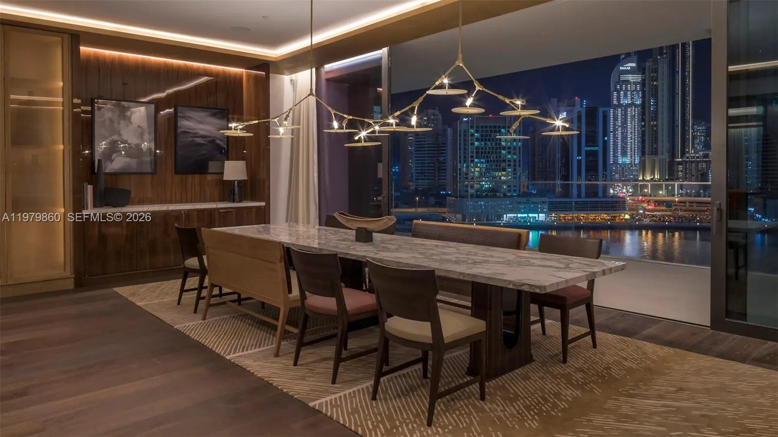 A dining room features a marble table, modern chandelier, and floor-to-ceiling city skyline views — 346 Marasi drive # 0, FL Dubai, FL