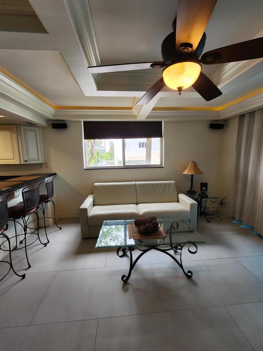A living room features a white sofa, glass coffee table, and a ceiling fan — 2080 E Hillsboro Boulevard # 108, Deerfield Beach FL 33441, DEERFIELD BEACH, FL