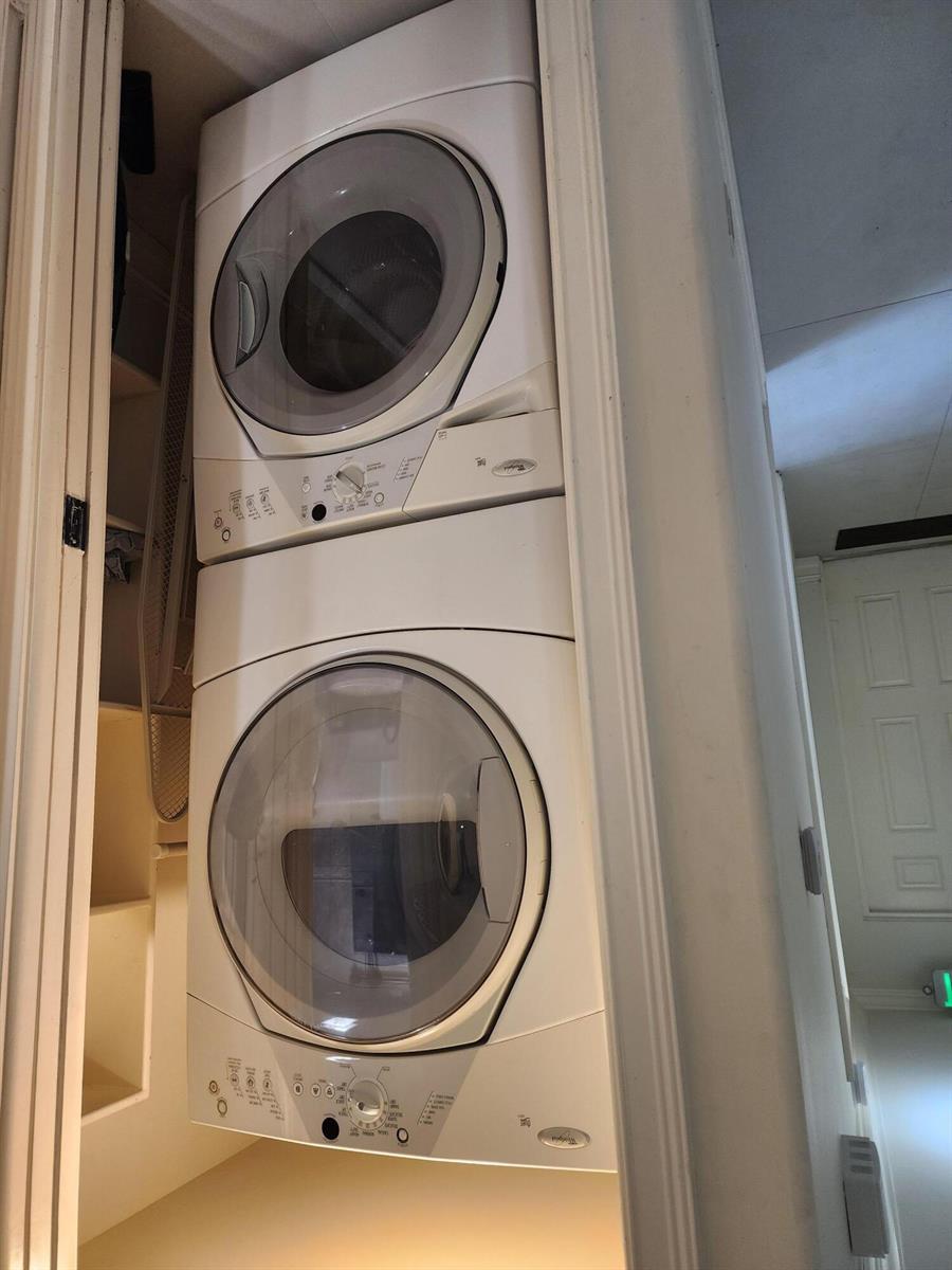 A stacked white washer and dryer unit are installed inside a closet — 2080 E Hillsboro Boulevard # 108, Deerfield Beach FL 33441, DEERFIELD BEACH, FL