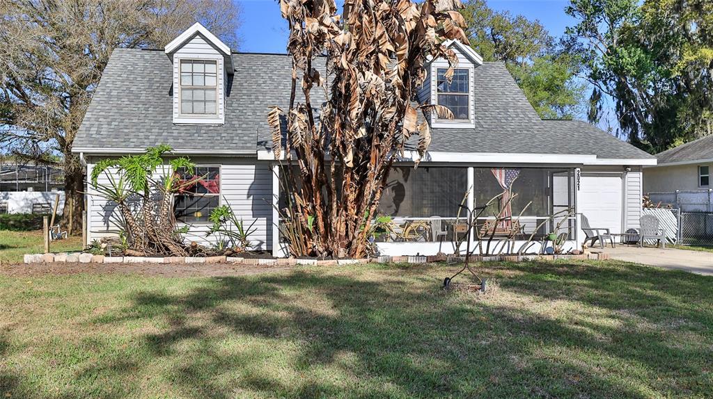 A one-story house with a screened front porch, two dormer windows, and an attached garage — 2021 UMBRELLA TREE DRIVE, EDGEWATER, FL
