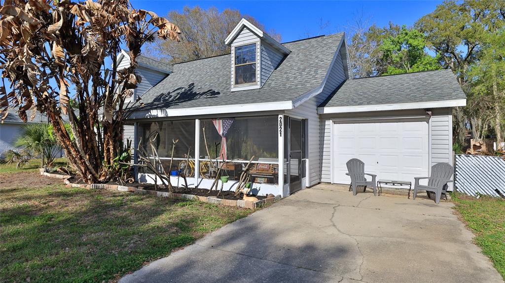 A screened-in porch features a tiled floor, a wooden bench, and a bicycle — 2021 UMBRELLA TREE DRIVE, EDGEWATER, FL