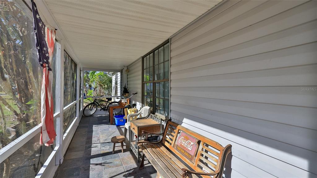 A living room features a ceiling fan, tiled floors, a television, and a display cabinet — 2021 UMBRELLA TREE DRIVE, EDGEWATER, FL