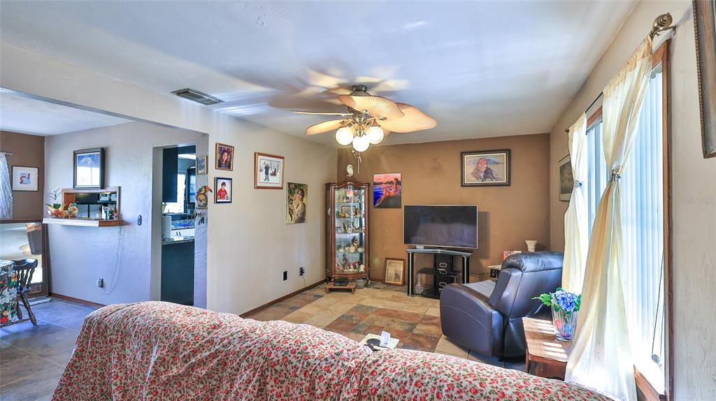 A living room with tile floors, a ceiling fan, and an adjacent dining area — 2021 UMBRELLA TREE DRIVE, EDGEWATER, FL