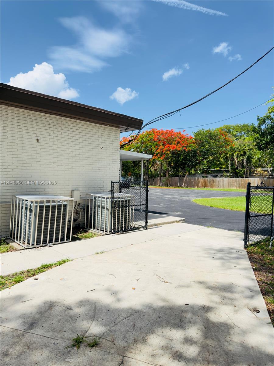 An exterior view shows two air conditioning units in metal cages beside a brick building — 1601 S 21st Ave, Hollywood FL 33020, HOLLYWOOD, FL
