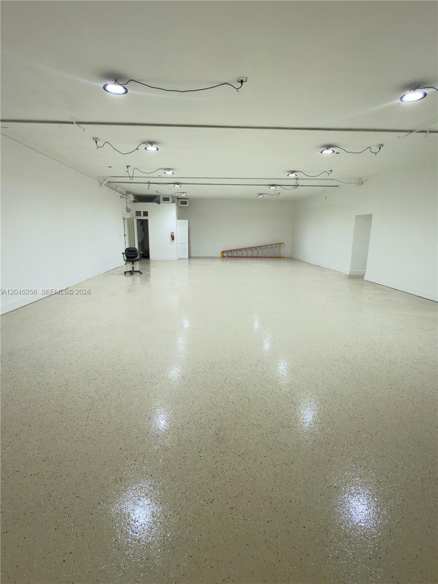 An empty commercial space features white walls, a speckled epoxy floor, and exposed ceiling lighting — 1601 S 21st Ave, Hollywood FL 33020, HOLLYWOOD, FL