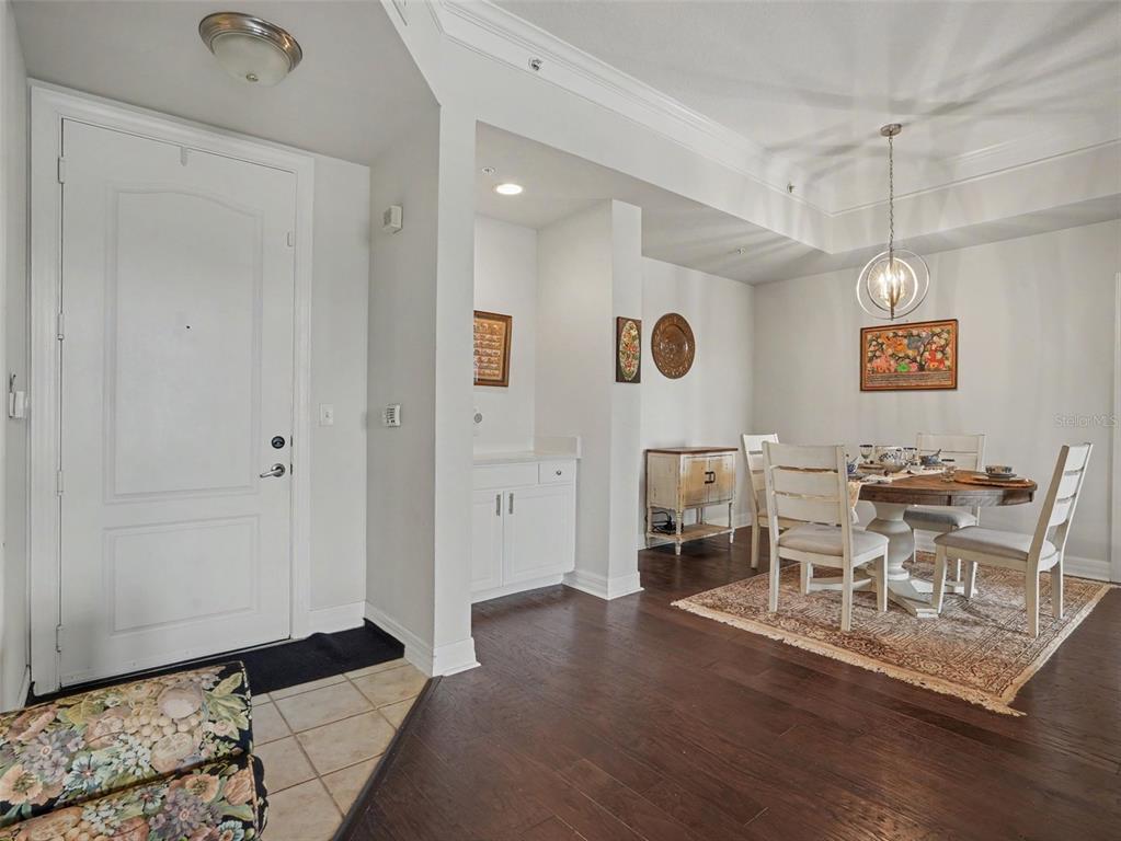 A dining area with a round table and chairs sits next to an entryway with tile — 501 MIRASOL CIRCLE UNIT 313, CELEBRATION, FL