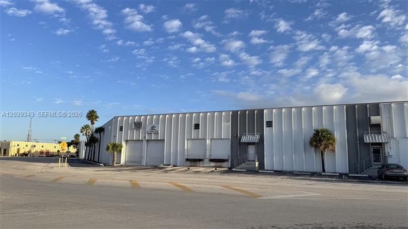 A low-rise industrial warehouse building features multiple loading docks and a paved parking lot — MIAMI, FL