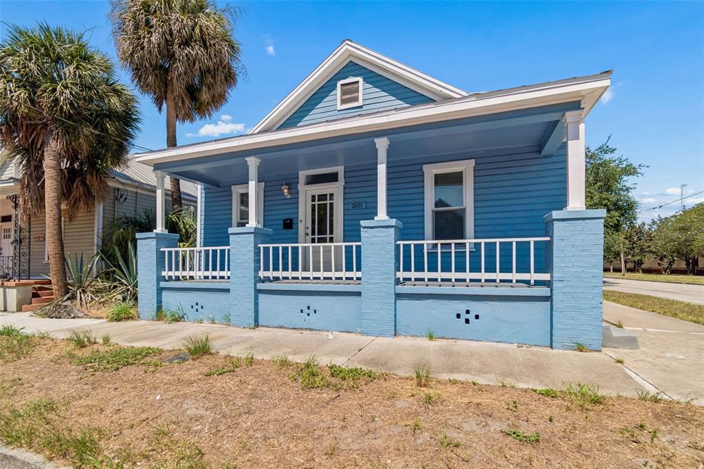 A blue, single-story house with a front porch and white railings stands on a corner lot — 2601 N 19TH STREET, TAMPA, FL