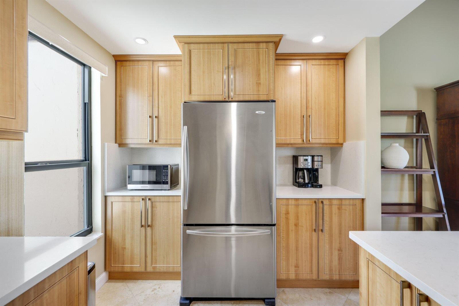 A kitchen features light wood cabinets, stainless steel appliances, and white countertops — 800 Greensward Court # I, Delray Beach FL 33445, DELRAY BEACH, FL