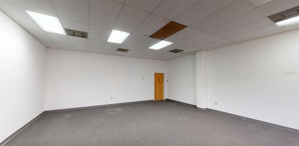 An empty office room with white walls, gray carpet, and a drop ceiling with lights — 1400 TROPIC PARK DRIVE UNIT 1490, SANFORD, FL