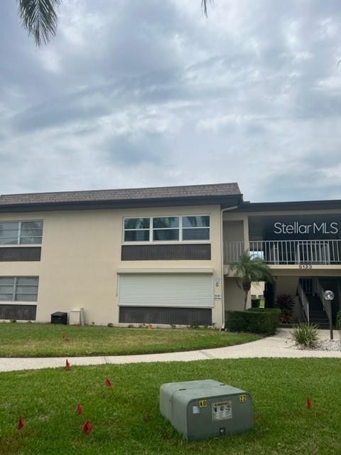 Exterior view of a two-story apartment building with a lawn and utility box in front — 5123 TOPAZ LANE UNIT 204G, NEW PORT RICHEY, FL