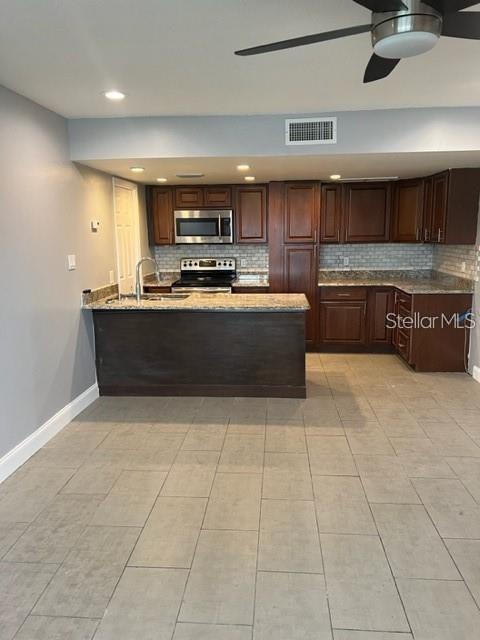 A kitchen features dark wood cabinets, granite countertops, a breakfast bar, and tile flooring — 5123 TOPAZ LANE UNIT 204G, NEW PORT RICHEY, FL