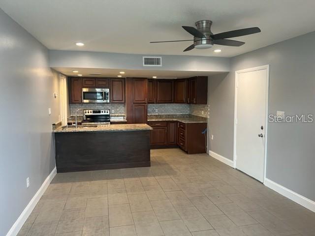 A kitchen features dark wood cabinets, a breakfast bar, and tile flooring — 5123 TOPAZ LANE UNIT 204G, NEW PORT RICHEY, FL