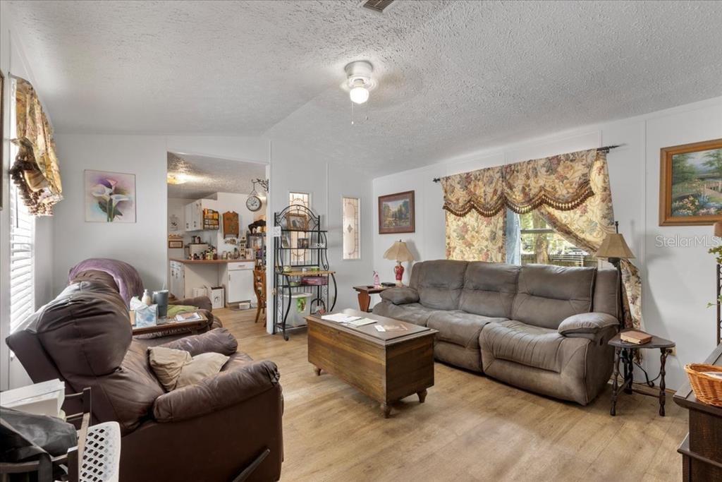 A living room features a brown sofa, a matching recliner, and a wooden coffee table — 901 NE 11TH AVENUE, TRENTON, FL
