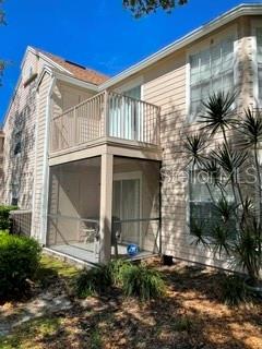 A two-story building features a screened-in ground-floor patio and an upper-level balcony with railings — 650 YOUNGSTOWN PARKWAY UNIT 215, ALTAMONTE SPRINGS, FL