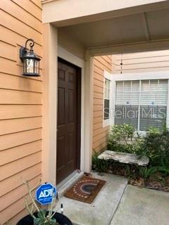 A brown front door is situated under a covered entryway with a wall-mounted light fixture — 650 YOUNGSTOWN PARKWAY UNIT 215, ALTAMONTE SPRINGS, FL