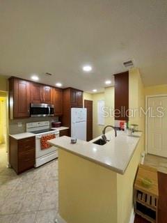 A kitchen features wood cabinets, a white refrigerator, and a peninsula with a countertop — 650 YOUNGSTOWN PARKWAY UNIT 215, ALTAMONTE SPRINGS, FL