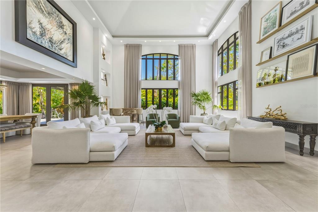 A spacious, high-ceilinged living room features white sectional sofas, a central coffee table, and large windows — 29 DORADO BEACH EAST, DORADO, PR