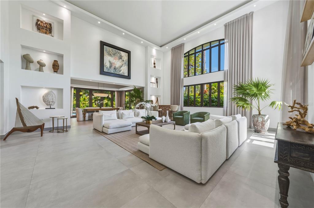 A spacious living room features high ceilings, white sofas, large windows, and built-in wall niches — 29 DORADO BEACH EAST, DORADO, PR