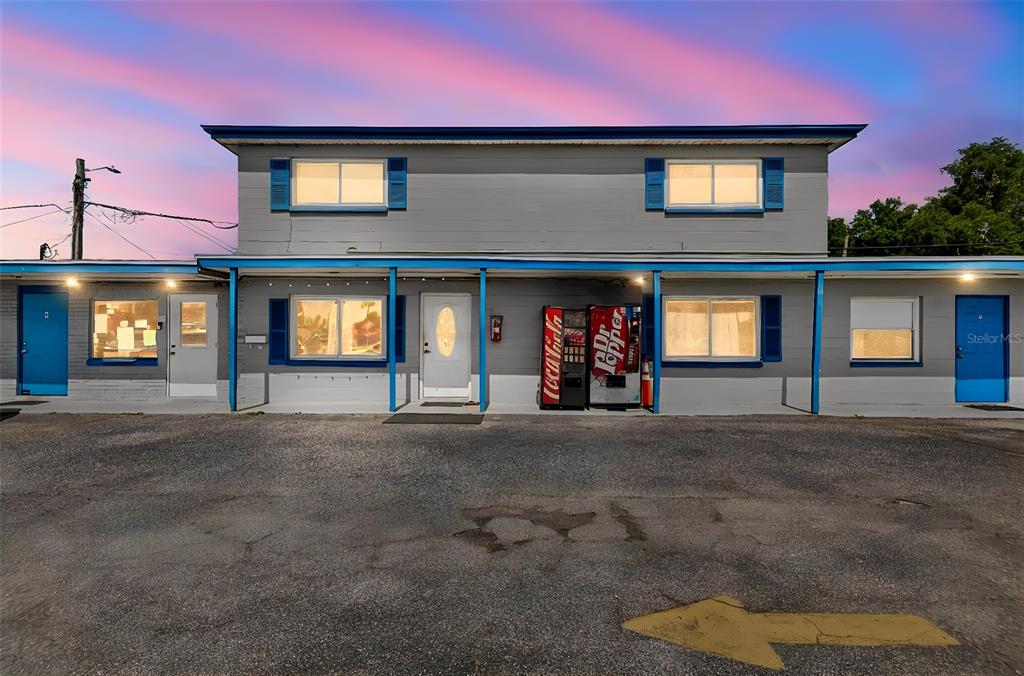A two-story motel building features gray siding, blue trim, and two vending machines outside — 6409 S DALE MABRY HIGHWAY, TAMPA, FL