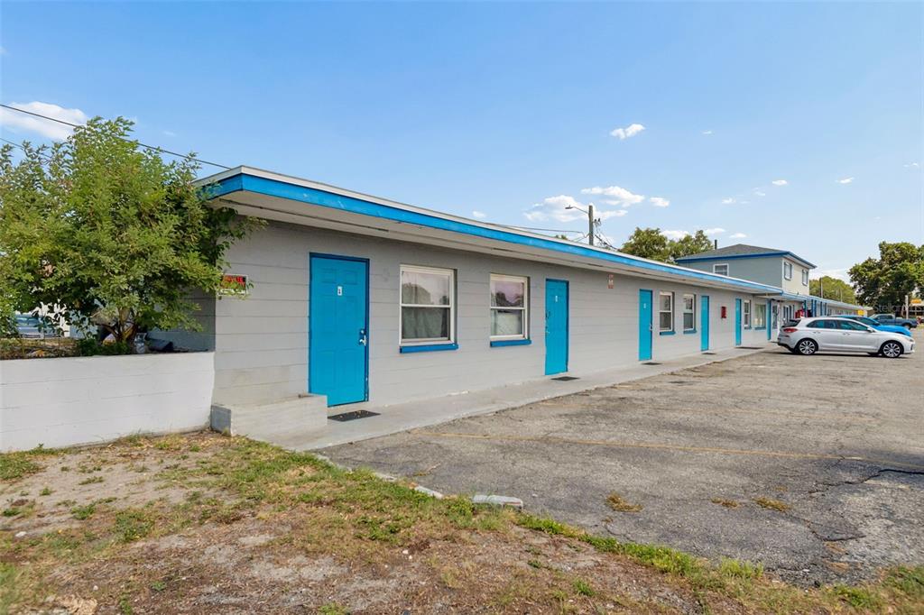 A single-story motel building with grey exterior walls and bright blue doors and trim — 6409 S DALE MABRY HIGHWAY, TAMPA, FL