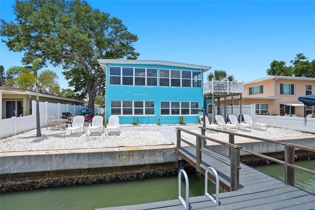 A two-story blue house sits on a waterfront lot with a private wooden dock — 2311 BAY BOULEVARD, INDIAN ROCKS BEACH, FL