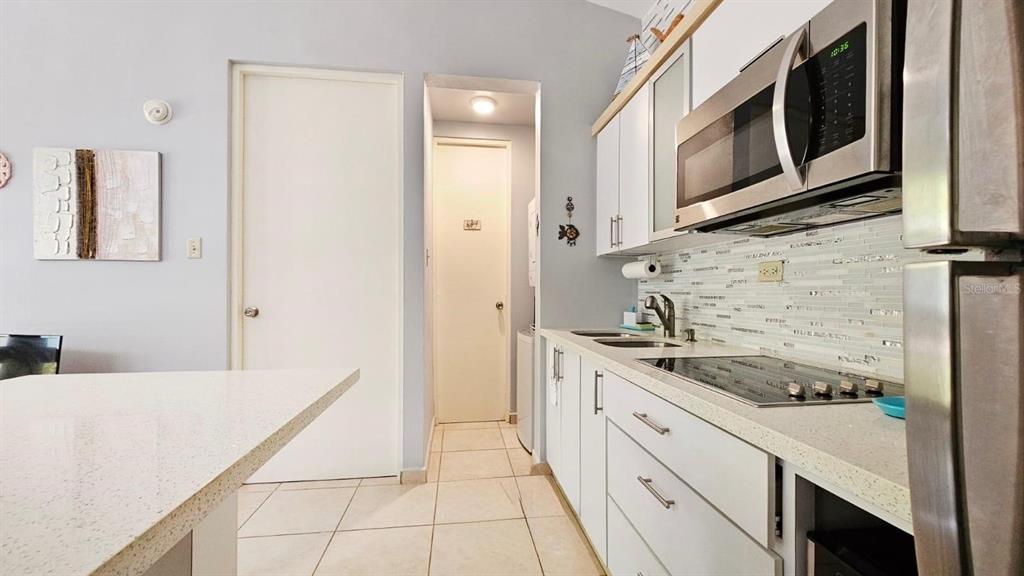 A kitchen features white cabinets, stainless steel appliances, a tiled backsplash, and light-colored countertops — Carr. PR 307 km 8.5 BOQUERÓN BAY SIDE INC, CABO ROJO, PR