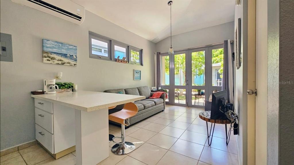 A small living room features a kitchen island, a gray sofa, and glass patio doors — Carr. PR 307 km 8.5 BOQUERÓN BAY SIDE INC, CABO ROJO, PR